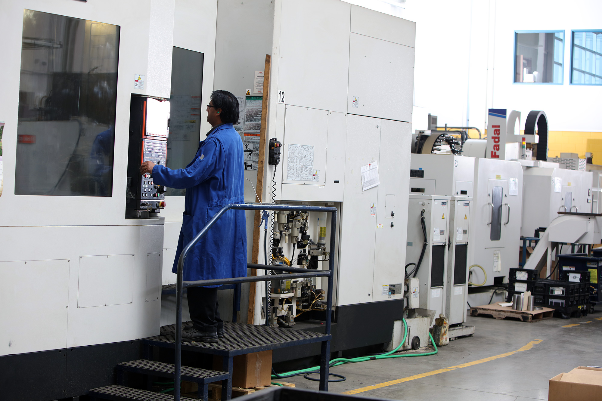 an employee stands at the controls of a vertical machining centre