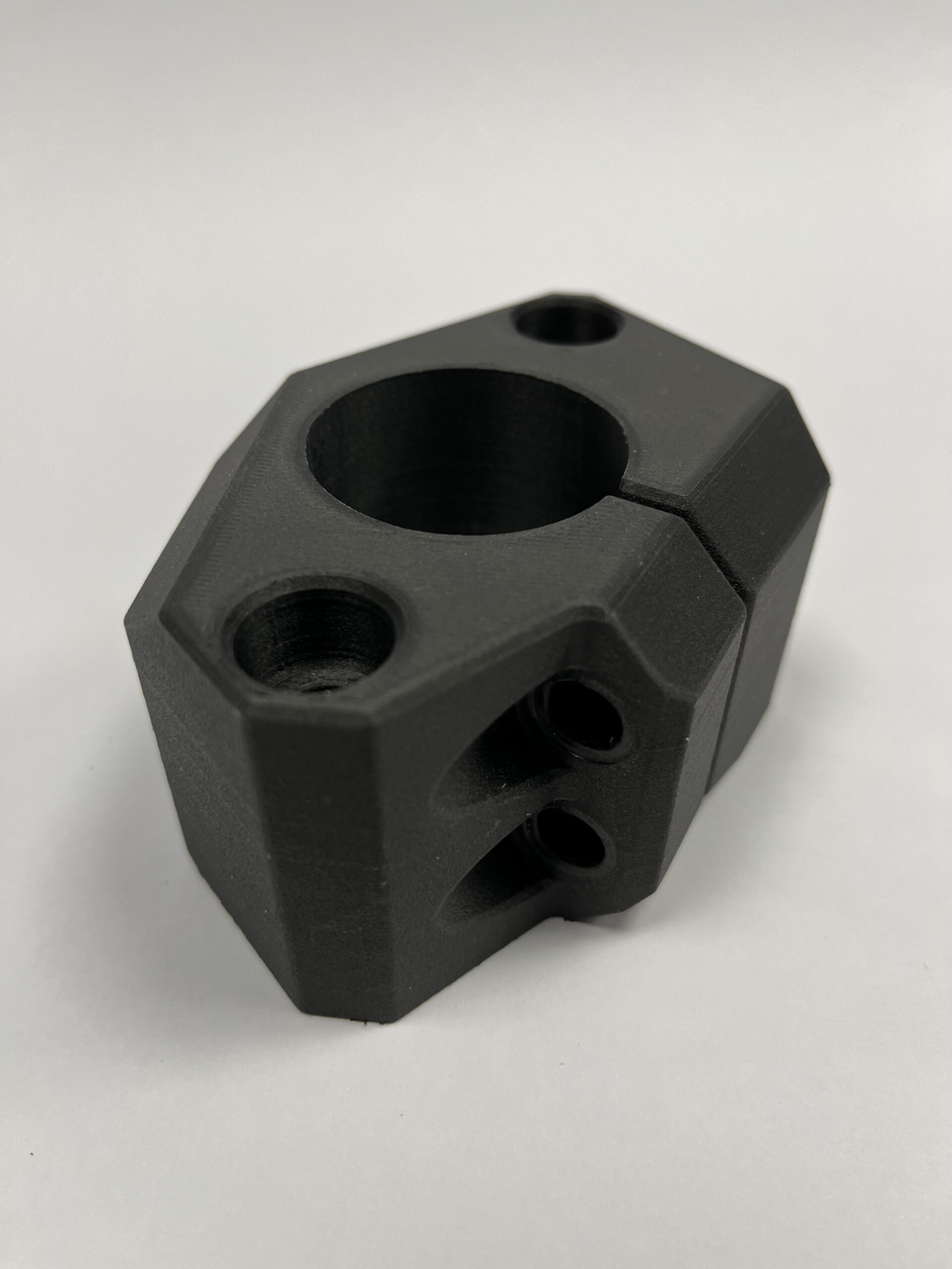 a 3D printed black plastic piece with several holes